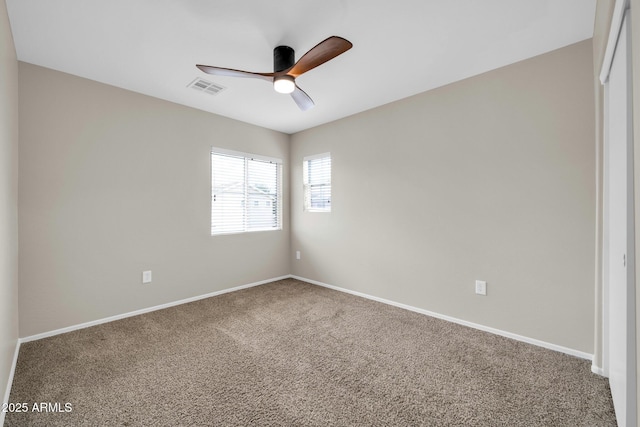 spare room featuring a ceiling fan, visible vents, carpet floors, and baseboards