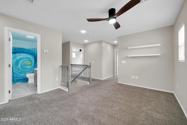 spare room featuring carpet flooring, baseboards, and ceiling fan