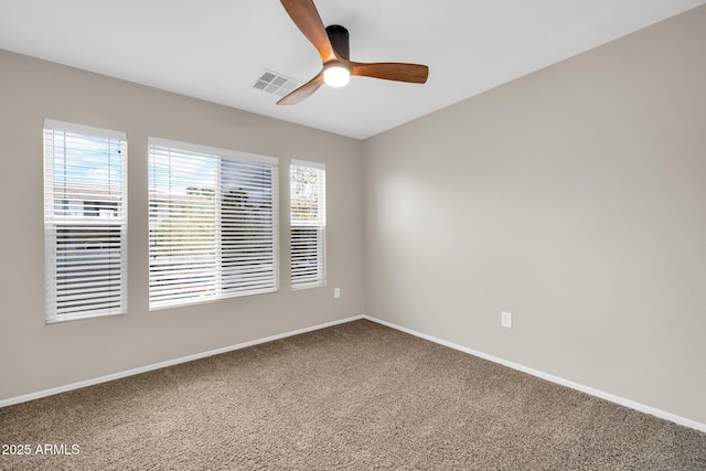 unfurnished room featuring a ceiling fan, visible vents, carpet floors, and baseboards