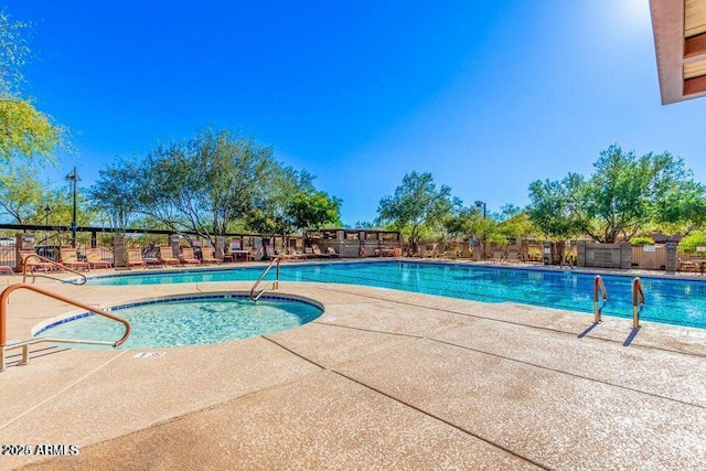 community pool featuring a patio area, a community hot tub, and fence