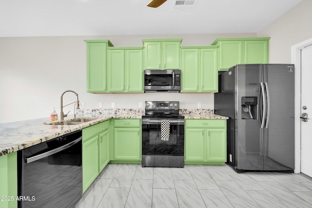 kitchen with light stone counters, visible vents, green cabinetry, a sink, and stainless steel appliances