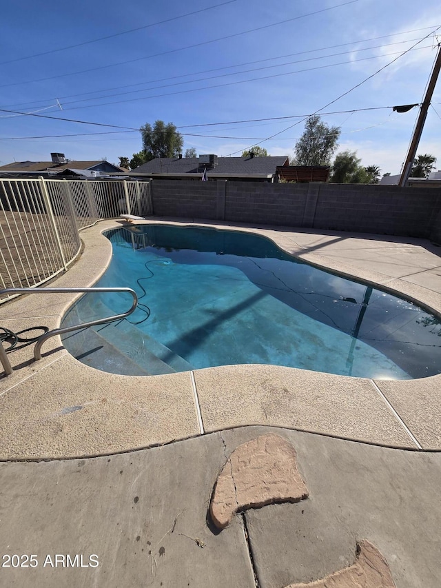 view of swimming pool with a diving board