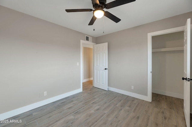 unfurnished bedroom featuring ceiling fan, light hardwood / wood-style floors, and a closet