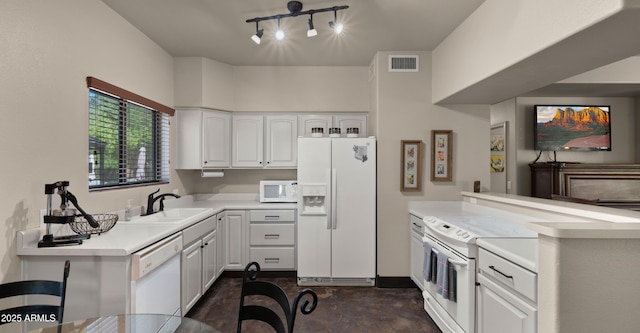 2311 W Dobbins Rd, Phoenix, AZ 85041 - kitchen with white appliances, a sink, a peninsula, light countertops, and white cabinets