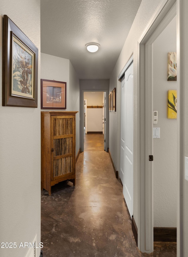 2311 W Dobbins Rd, Phoenix, AZ 85041 - hallway featuring concrete floors, a textured ceiling, and baseboards