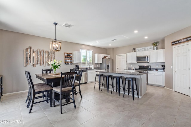 dining area with a notable chandelier and light tile patterned flooring