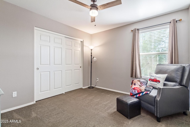 sitting room with dark colored carpet and ceiling fan