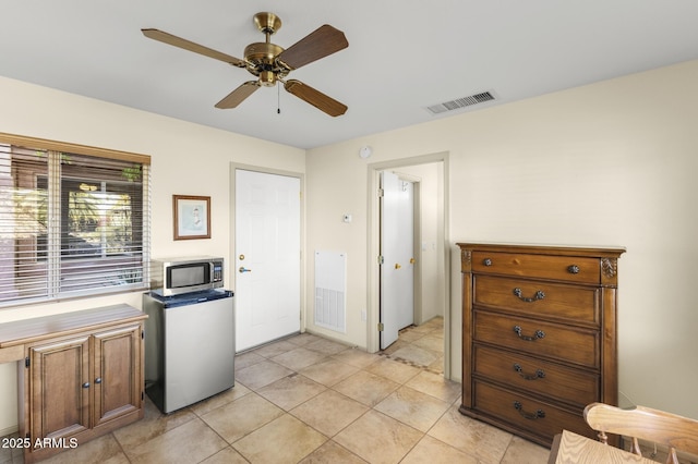 17882 N Painted Spurge Ct, Surprise, AZ 85374 - kitchen with refrigerator, light tile patterned floors, stainless steel microwave, visible vents, and ceiling fan