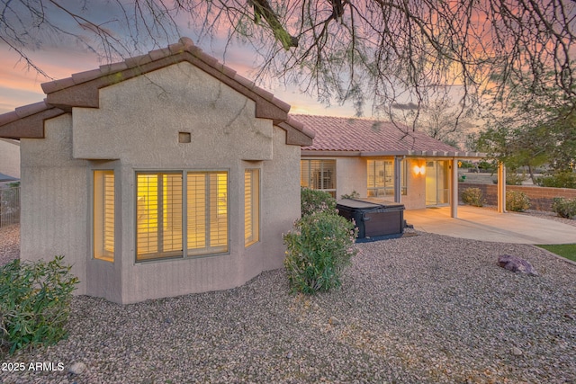 17882 N Painted Spurge Ct, Surprise, AZ 85374 - exterior space featuring stucco siding, a hot tub, a patio area, fence, and a tiled roof