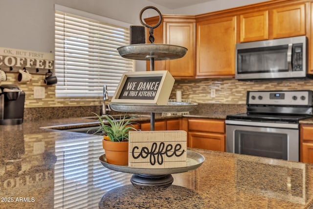 2198 W Pima Ave, Coolidge, AZ 85128 - kitchen featuring stainless steel appliances, decorative backsplash, dark stone counters, and brown cabinetry