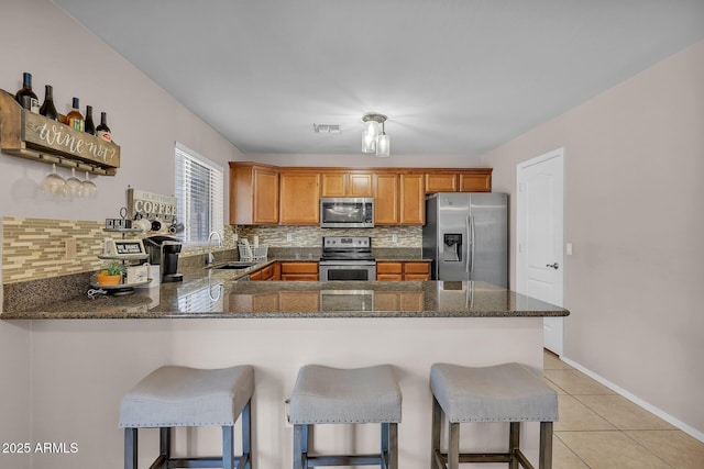 2198 W Pima Ave, Coolidge, AZ 85128 - kitchen featuring stainless steel appliances, backsplash, a peninsula, and dark stone counters