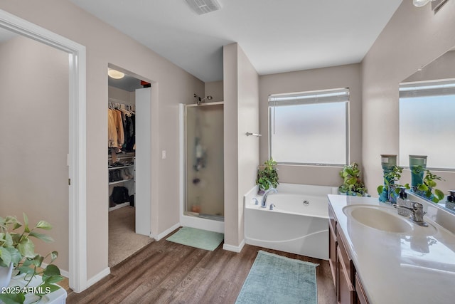 2198 W Pima Ave, Coolidge, AZ 85128 - full bath with a stall shower, vanity, a garden tub, a spacious closet, and wood finished floors