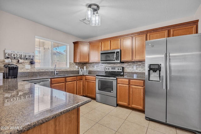 2198 W Pima Ave, Coolidge, AZ 85128 - kitchen featuring stainless steel appliances, backsplash, brown cabinets, and light tile patterned flooring
