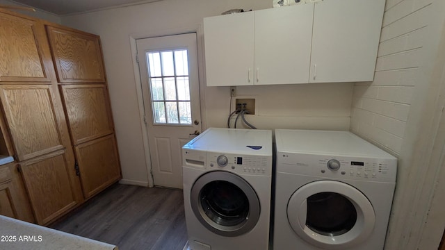 laundry room featuring cabinet space, wood finished floors, and washer and clothes dryer