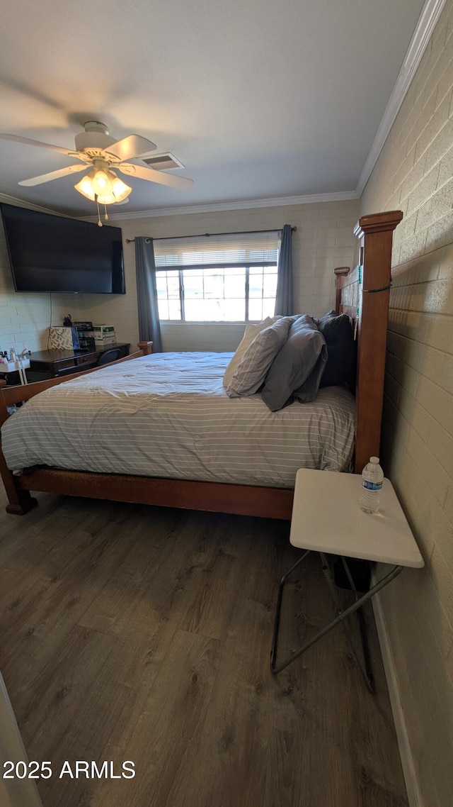 bedroom featuring visible vents, wood finished floors, a ceiling fan, and ornamental molding