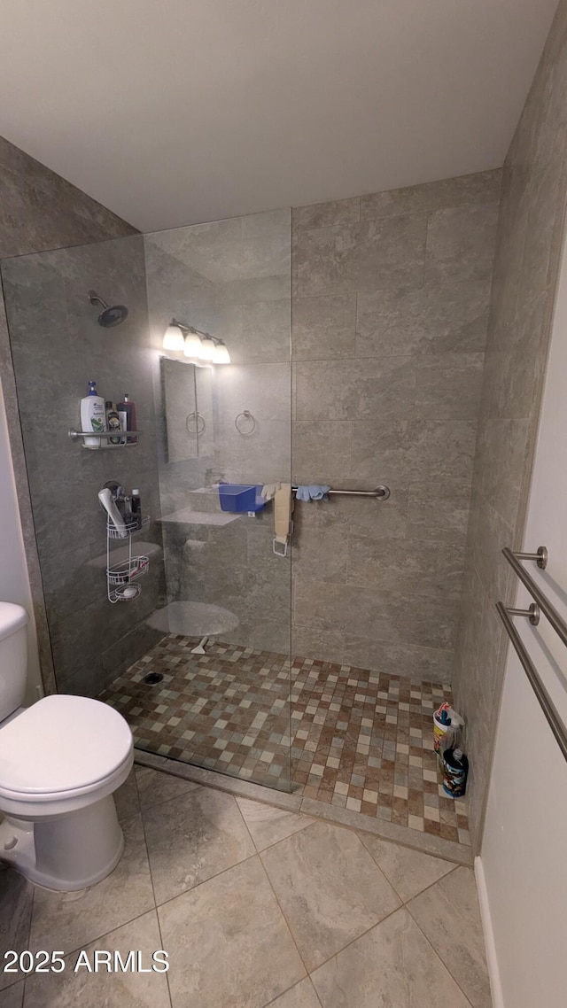 full bathroom featuring toilet and a tile shower