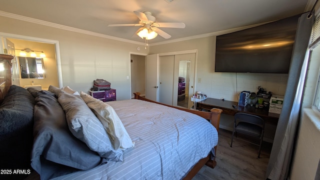 bedroom featuring crown molding, ensuite bathroom, wood finished floors, a closet, and a ceiling fan