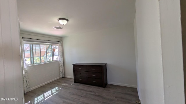 unfurnished bedroom with visible vents, baseboards, and wood finished floors