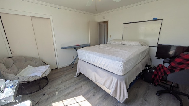 bedroom featuring a closet, light wood finished floors, and ornamental molding