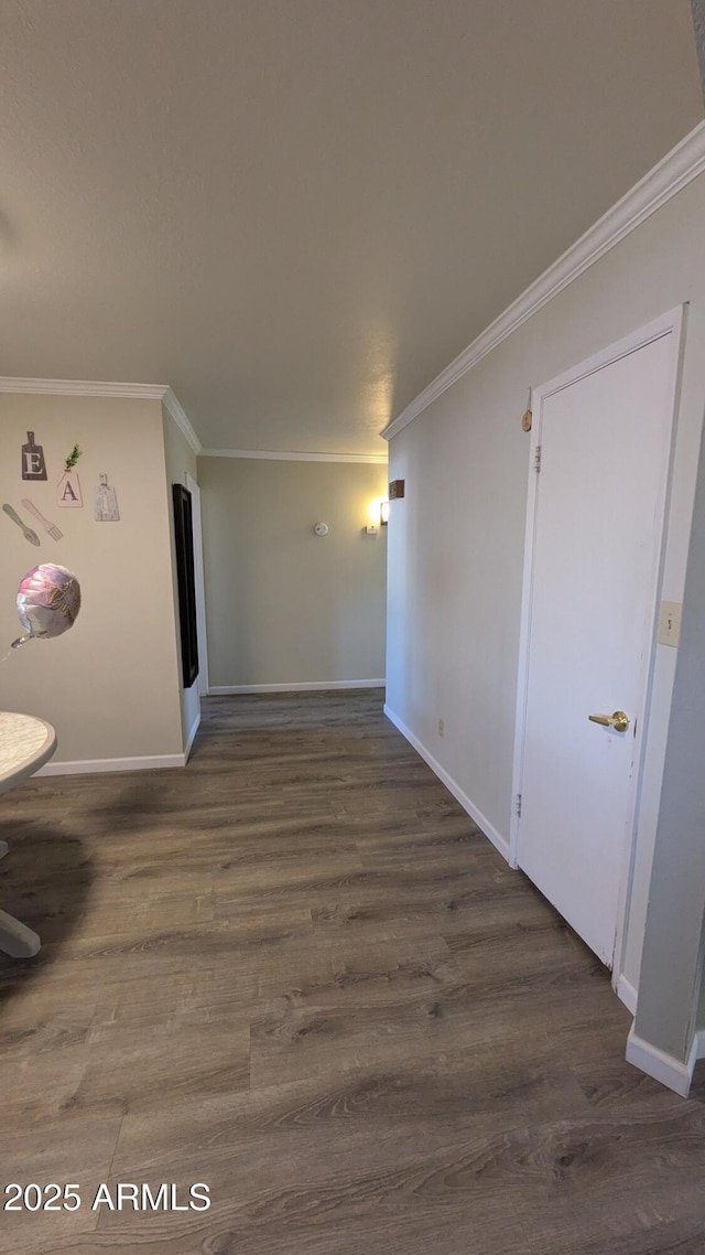 interior space featuring wood finished floors, baseboards, and ornamental molding