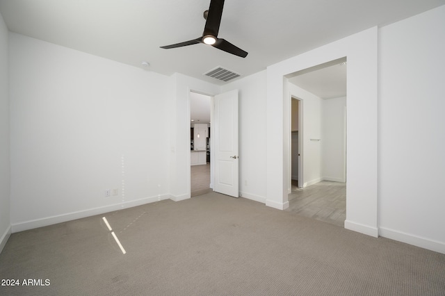 unfurnished bedroom featuring light carpet and ceiling fan