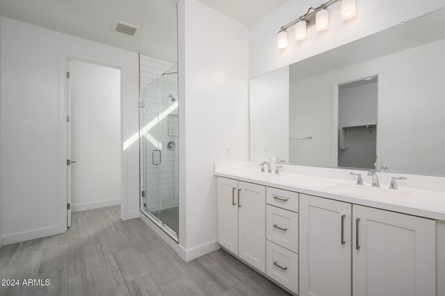 bathroom with vanity, a shower with shower door, and hardwood / wood-style flooring