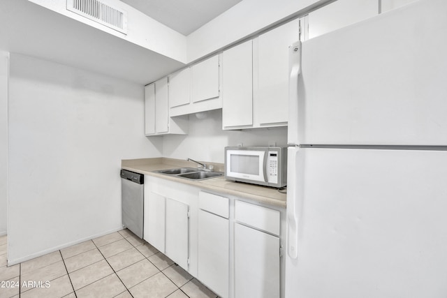 kitchen featuring light tile patterned flooring, white appliances, white cabinetry, and sink