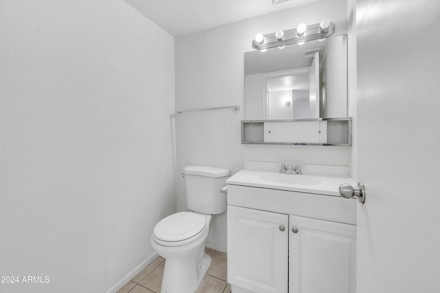 bathroom with toilet, vanity, and tile patterned floors