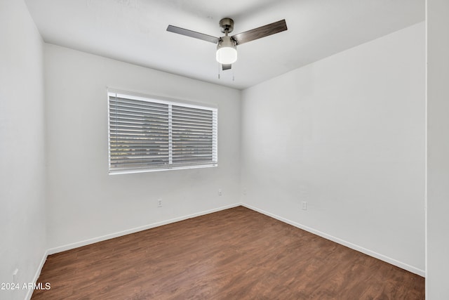 spare room featuring ceiling fan and dark wood-type flooring