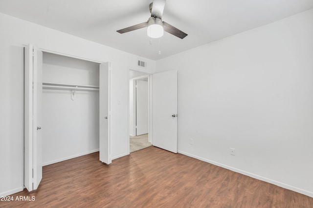 unfurnished bedroom featuring a closet, ceiling fan, and dark hardwood / wood-style flooring