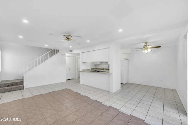 kitchen featuring ceiling fan, white cabinets, white fridge, and light tile patterned floors