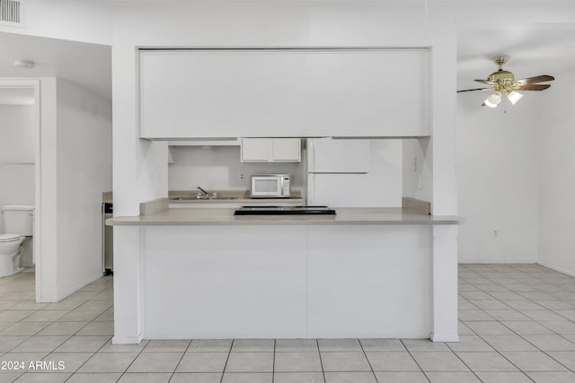 kitchen with white appliances, white cabinetry, ceiling fan, and light tile patterned flooring