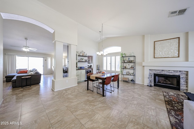 4558 E Libby St, Phoenix, AZ 85032 - dining area featuring a fireplace, ceiling fan, a chandelier, baseboards, and arched walkways