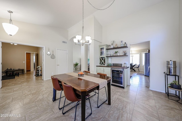 4558 E Libby St, Phoenix, AZ 85032 - dining room featuring wine cooler, a towering ceiling, a chandelier, baseboards, and a bar