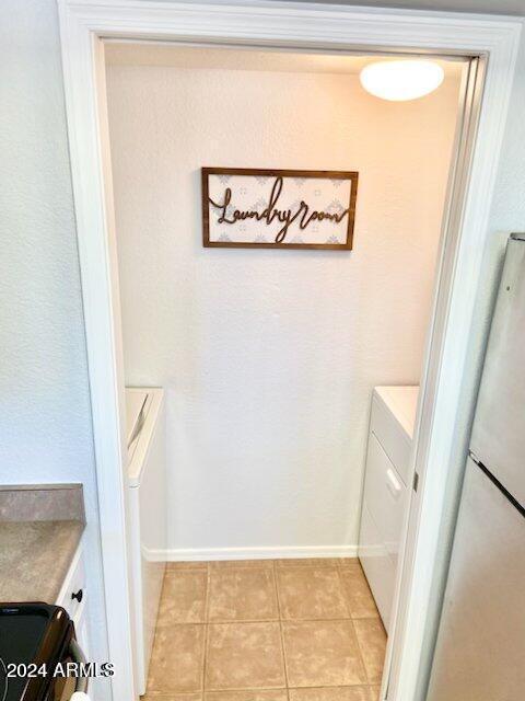 laundry area featuring light tile patterned floors and independent washer and dryer