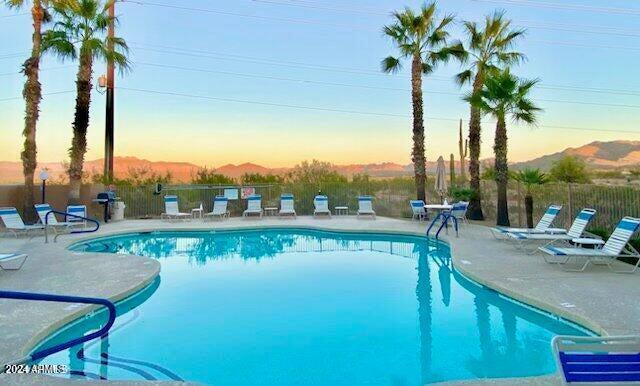 pool at dusk with a patio area