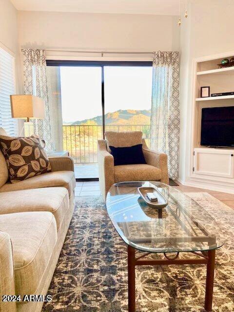 living room featuring tile patterned floors, built in features, and a healthy amount of sunlight