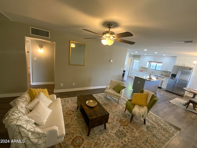 living room with ceiling fan and dark wood-type flooring