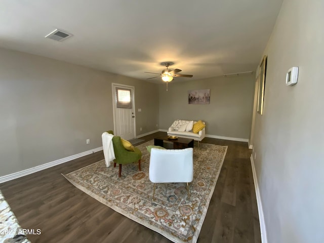 living room featuring ceiling fan and dark wood-type flooring