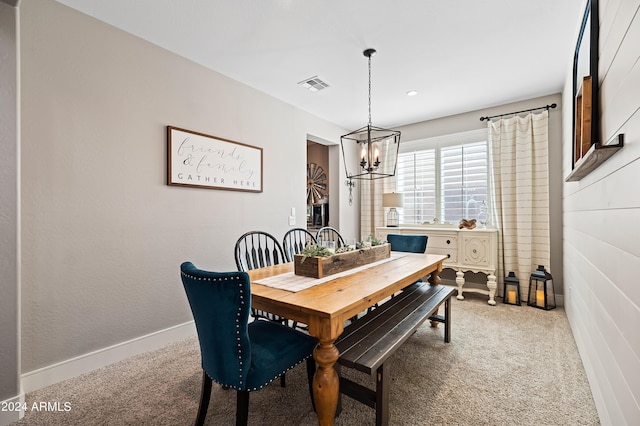 dining room featuring visible vents, light colored carpet, baseboards, and an inviting chandelier