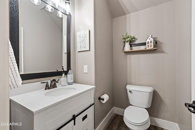 bathroom featuring vanity, toilet, wood finished floors, and baseboards