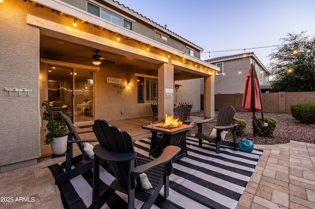 view of patio with an outdoor fire pit, ceiling fan, and fence