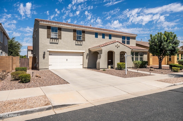 view of front of house with fence, driveway, stucco siding, a garage, and a tiled roof