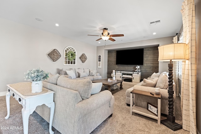 living area featuring carpet, visible vents, recessed lighting, ceiling fan, and an accent wall