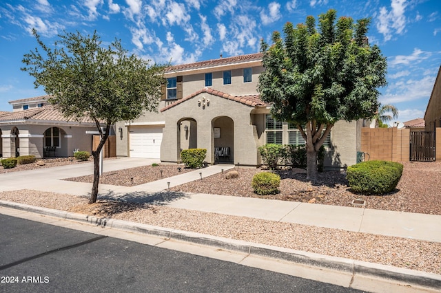 view of front of property with stucco siding, driveway, a tile roof, fence, and an attached garage