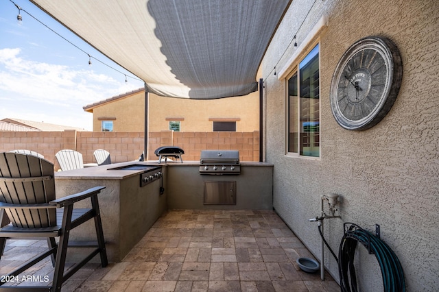 view of patio / terrace featuring a grill, an outdoor kitchen, and fence