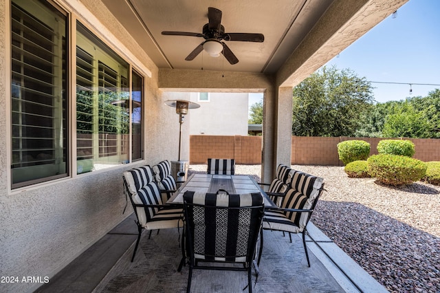 view of patio with outdoor dining area, a ceiling fan, and fence