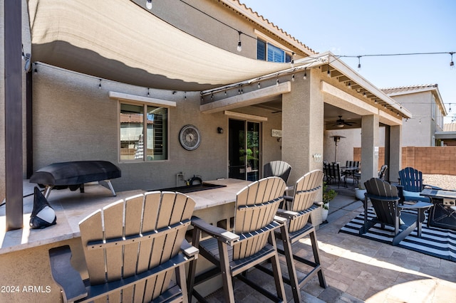 view of patio / terrace featuring outdoor dining area, outdoor dry bar, a ceiling fan, and fence