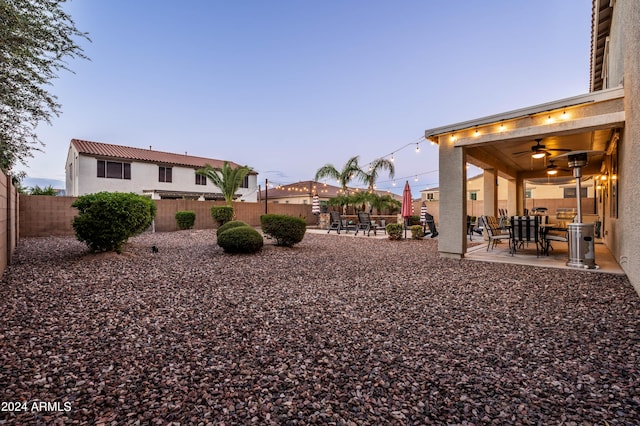 view of yard with a patio area, ceiling fan, and a fenced backyard