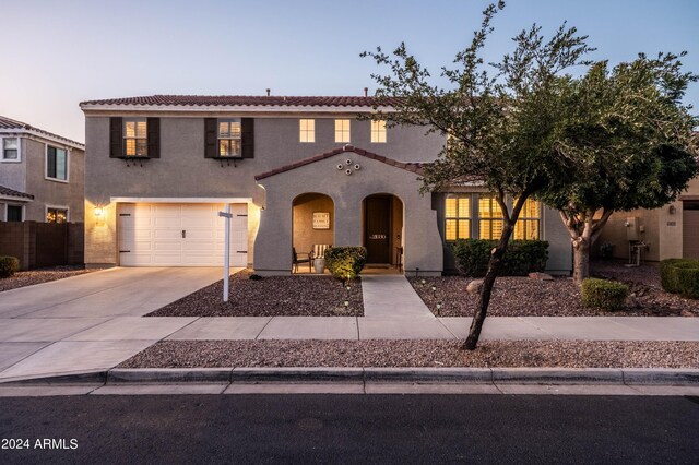 view of front of property with fence, an attached garage, stucco siding, concrete driveway, and a tile roof